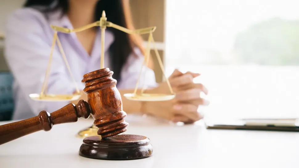 Martelo de juiz e balança da justiça sobre mesa de escritório